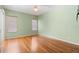 Bright bedroom with hardwood floors, fresh green paint, and abundant natural light at 3593 Scoutoak Loop, Oviedo, FL 32765