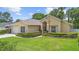 Traditional home featuring an attached garage, lush front yard, and mature landscaping at 3593 Scoutoak Loop, Oviedo, FL 32765