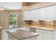 Well-lit kitchen featuring granite countertops, white cabinets, and stainless steel dishwasher at 3593 Scoutoak Loop, Oviedo, FL 32765