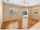 Open living room with hardwood floors, a ceiling fan, and sliding glass door to lanai with pool view at 3593 Scoutoak Loop, Oviedo, FL 32765