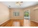 Comfortable living room with hardwood floors, a ceiling fan, and a sliding glass door to the outdoor pool area at 3593 Scoutoak Loop, Oviedo, FL 32765