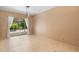 An open room with light tile floors, tan walls, and sliding glass doors to the pool area at 3593 Scoutoak Loop, Oviedo, FL 32765