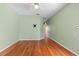 Green living room with hardwood floors, ceiling fan, wall-mounted TV bracket, and white baseboards at 3593 Scoutoak Loop, Oviedo, FL 32765