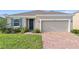 Charming single-Gathering home featuring a two-car garage, brick driveway, and well-maintained lawn at 417 Tisone Ln, Davenport, FL 33837