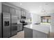 Modern kitchen with stainless steel appliances, gray cabinets, and a large quartz countertop island at 417 Tisone Ln, Davenport, FL 33837