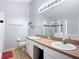 Updated bathroom with a glass-enclosed shower, large mirror, and double sink vanity at 4611 Cumbrian Lakes Dr, Kissimmee, FL 34746