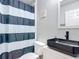 Modern bathroom featuring a black vessel sink, black faucet and black and white striped shower curtain at 4611 Cumbrian Lakes Dr, Kissimmee, FL 34746