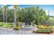Community entrance featuring a stone sign, tiered water feature, and lush green landscaping at 4611 Cumbrian Lakes Dr, Kissimmee, FL 34746