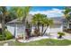 Well-maintained home with a brick driveway, manicured lawn, and tropical landscaping featuring palm trees at 4611 Cumbrian Lakes Dr, Kissimmee, FL 34746