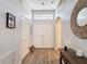 Bright foyer with wood floors, white double doors, transom window, and decorative mirror at 4611 Cumbrian Lakes Dr, Kissimmee, FL 34746