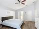 Spacious main bedroom with a ceiling fan, wood-look floors, and ensuite bathroom with a white dresser at 4611 Cumbrian Lakes Dr, Kissimmee, FL 34746