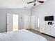 Spacious main bedroom with a ceiling fan, wood-look floors, and ensuite bathroom with a white dresser at 4611 Cumbrian Lakes Dr, Kissimmee, FL 34746
