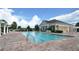 Beautiful community pool with an elegant clubhouse in the background, surrounded by meticulously maintained grounds at 4850 Waltham Forest Dr, Davenport, FL 33837
