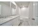 Bathroom with double sink, granite counters, tile floors, and a white tiled shower and tub at 491 Whistling Duck Trl, St Cloud, FL 34771