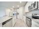 Well-lit kitchen featuring stainless steel appliances, white cabinetry, and a granite island with seating at 491 Whistling Duck Trl, St Cloud, FL 34771