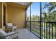 Screened balcony overlooking lush greenery and a tranquil pond, perfect for outdoor relaxation at 500 Mirasol Cir # 203, Celebration, FL 34747