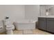 Corner soaking tub with separate toilet and a dark grey vanity cabinet in a neutral-colored tiled bathroom at 500 Mirasol Cir # 203, Celebration, FL 34747
