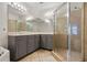 Bright bathroom featuring double sinks, a large mirror, and glass-enclosed shower with neutral tile at 500 Mirasol Cir # 203, Celebration, FL 34747