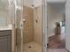 Shower with glass door and neutral tile is steps away from the bedroom in this home at 500 Mirasol Cir # 203, Celebration, FL 34747