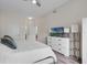 Well-lit bedroom with hardwood floors, large dresser, and a glimpse into the primary bath at 500 Mirasol Cir # 203, Celebration, FL 34747