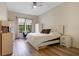 Bright bedroom with wood floors, ceiling fan, and large window with view of mature landscaping at 500 Mirasol Cir # 203, Celebration, FL 34747