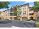 Exterior view of condo building with multiple levels, garage parking, screened porches, and mature landscaping at 500 Mirasol Cir # 203, Celebration, FL 34747