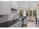 Well-lit kitchen featuring gray cabinets, granite countertops, tile backsplash, and stainless steel appliances at 500 Mirasol Cir # 203, Celebration, FL 34747