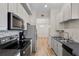 Modern kitchen featuring stainless steel appliances, granite countertops, and wood-style flooring at 500 Mirasol Cir # 203, Celebration, FL 34747