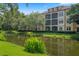 Picturesque view of the property overlooking a pond, showcasing manicured landscaping and building facade at 500 Mirasol Cir # 203, Celebration, FL 34747