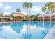 Community pool surrounded by palm trees and cabanas at 500 Mirasol Cir # 203, Celebration, FL 34747