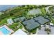 Aerial view featuring tennis courts, a pool, a putting green, and a scenic pond at 5081 Twin Lakes Blvd, St Cloud, FL 34772