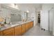 Spacious bathroom featuring double sinks with granite countertops, wooden cabinets, and a glass-enclosed shower at 5081 Twin Lakes Blvd, St Cloud, FL 34772
