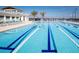 Swimming pool with lanes, sun loungers, palm trees, and community building in the background, perfect for relaxing at 5081 Twin Lakes Blvd, St Cloud, FL 34772