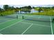 Well-maintained tennis courts with lush landscaping, perfect for outdoor recreation with a view of the pond at 5081 Twin Lakes Blvd, St Cloud, FL 34772