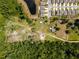 Aerial view of a large lot surrounded by lush greenery, lake, and houses at 5365 Rambling Rd, St Cloud, FL 34771