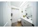 Bright bathroom with modern vanity, sleek fixtures, skylight, shower with curtain and gray flooring at 5365 Rambling Rd, St Cloud, FL 34771