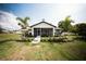 Charming home with well-manicured lawn, palm trees, and a cozy screened-in porch, perfect for outdoor relaxation at 5365 Rambling Rd, St Cloud, FL 34771