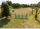 Green grass and fencing with a gated entrance in this vacant lot at 5365 Rambling Rd, St Cloud, FL 34771