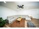 Cozy living room with a plush sectional sofa, ceiling fan, and a warm rug, creating an inviting atmosphere at 5365 Rambling Rd, St Cloud, FL 34771