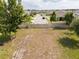 This is a view of the vacant lot, bounded by fencing, near a neighborhood road at 5365 Rambling Rd, St Cloud, FL 34771