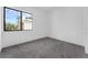 A simple bedroom with grey carpet, white walls, and a window view at 56 W Harding St, Orlando, FL 32806