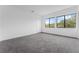 Bright bedroom with grey carpet, minimal design, and large windows offering natural light and an exterior view at 56 W Harding St, Orlando, FL 32806