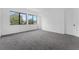 Spacious bedroom with natural light from multiple windows, neutral grey carpet, and a minimalist white interior at 56 W Harding St, Orlando, FL 32806
