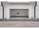 View of an empty two car garage with white interior walls and gray stained concrete floors at 56 W Harding St, Orlando, FL 32806