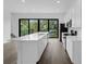 Bright modern kitchen with stainless steel appliances and a large island with a sink and black framed sliding glass doors at 56 W Harding St, Orlando, FL 32806
