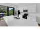 A modern kitchen with stainless steel appliances, white cabinetry, and a large island with a sink and white countertop at 56 W Harding St, Orlando, FL 32806