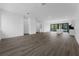 Bright open floor plan with wood floors, white walls, kitchen island, and balcony doors at 56 W Harding St, Orlando, FL 32806