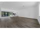 Spacious living area showcasing dark flooring, kitchen with island, and balcony with natural light at 56 W Harding St, Orlando, FL 32806
