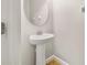 Compact powder room featuring a pedestal sink, minimalist decor, and neutral tones, maximizing space efficiency at 5911 Grassy Point Rd, Winter Garden, FL 34787