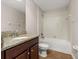 Well-lit bathroom featuring a granite countertop, updated fixtures, and a shower-tub combination at 5911 Grassy Point Rd, Winter Garden, FL 34787